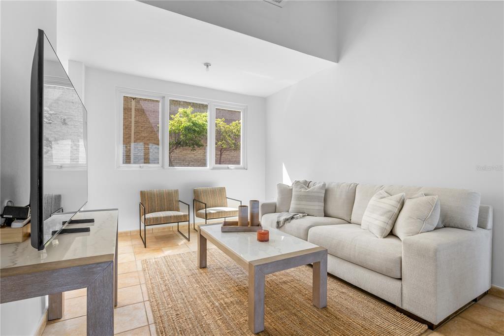 A living room features a white sofa, two armchairs, a coffee table, and tile flooring — 10 I UNIT 201, RIO GRANDE, PR