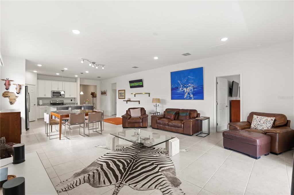 An aerial view shows a single-story suburban house with a gray garage and shingled roof — 1580 BLUE LAGOON CIRCLE, MASCOTTE, FL