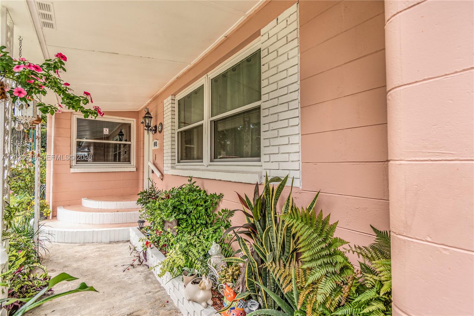 A pink exterior wall features white brick window trim and a covered front porch — 145 N ORANGE ST, Starke FL 32091, STARKE, FL