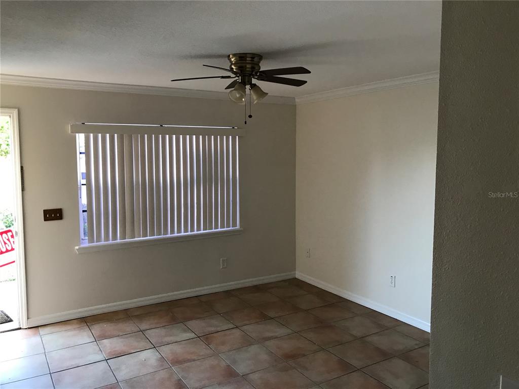 An empty room features tiled flooring, a ceiling fan, and a window with vertical blinds — 354 CERVANTES DRIVE, KISSIMMEE, FL