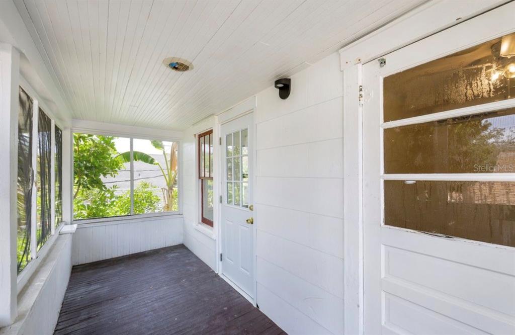 A covered porch with white walls, a dark wood floor, and large windows — 622 7TH AVENUE N UNIT 618B, ST PETERSBURG, FL