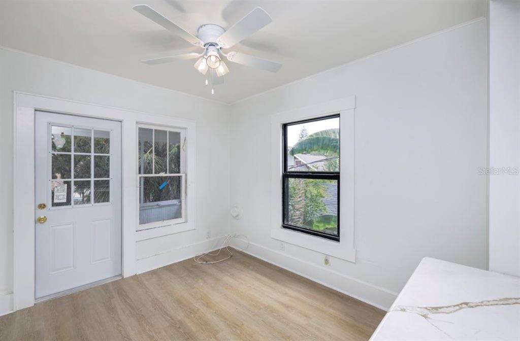 A bright room with white walls, wood-look flooring, a ceiling fan, and two windows — 622 7TH AVENUE N UNIT 618B, ST PETERSBURG, FL
