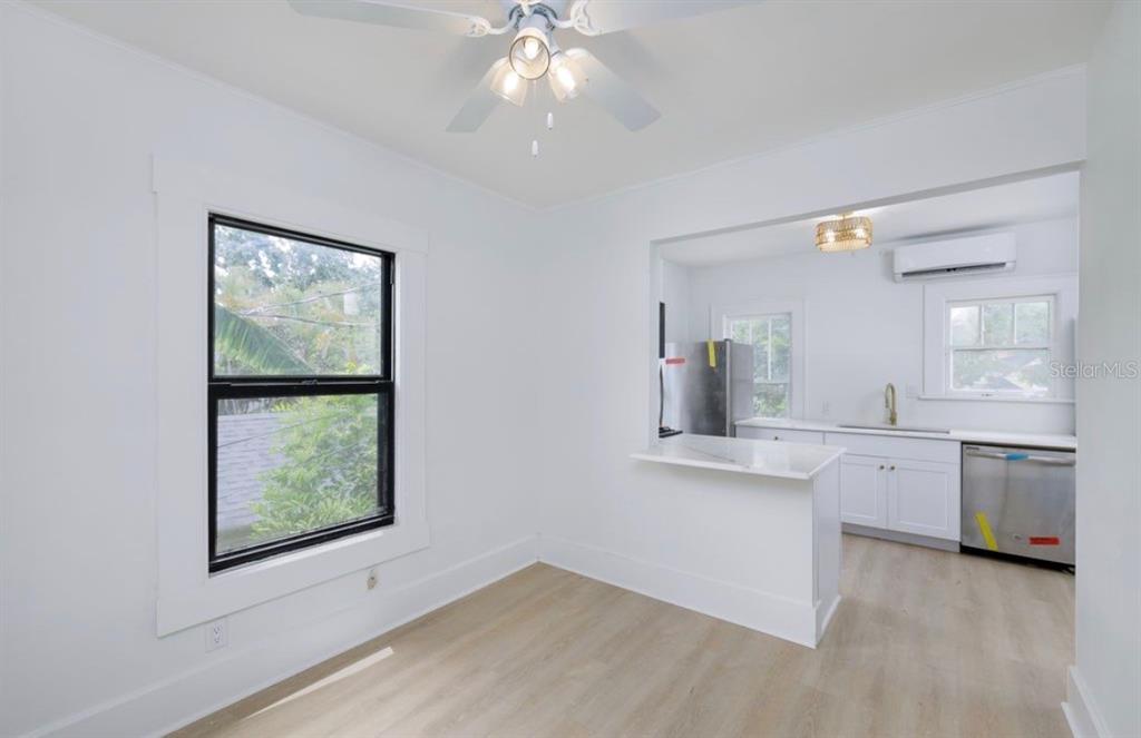 A dining area with light wood floors opens into a white kitchen with stainless appliances — 622 7TH AVENUE N UNIT 618B, ST PETERSBURG, FL