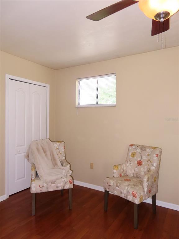 A room with wood-look flooring, two floral armchairs, a closet, and a ceiling fan — 4427 SW 21ST LANE, GAINESVILLE, FL