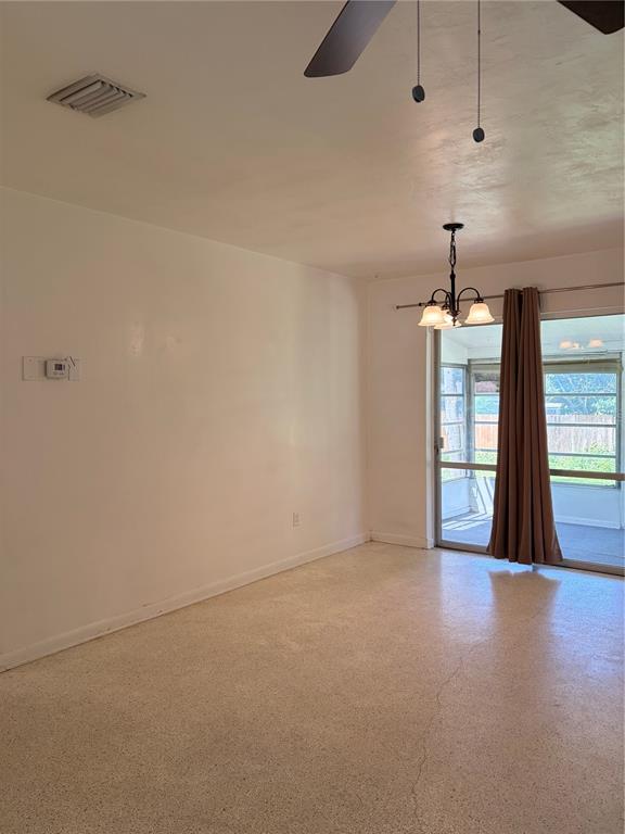 A dining area with a chandelier, ceiling fan, and sliding glass doors leading to a porch — 1320 HARTLEY AVENUE, DELTONA, FL