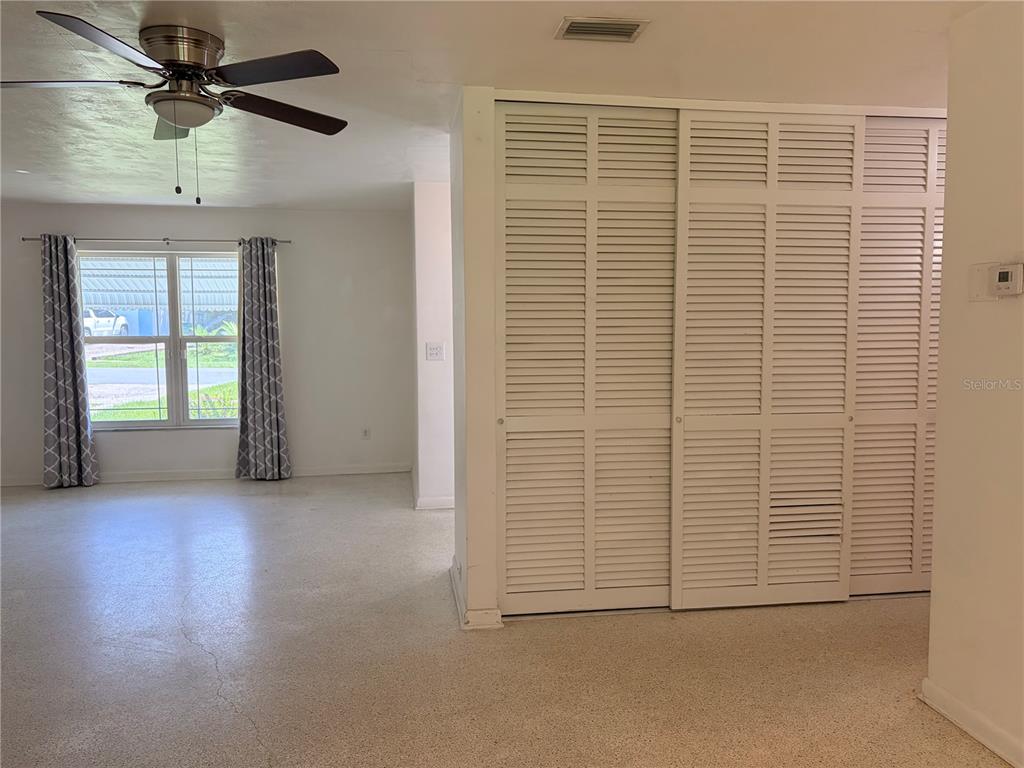 A room with a ceiling fan, white louvered closet doors, and a window with curtains — 1320 HARTLEY AVENUE, DELTONA, FL