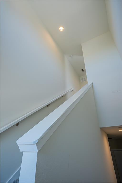 A staircase with a white handrail leads upward toward a landing with recessed lighting — 339 8TH STREET N, ST PETERSBURG, FL