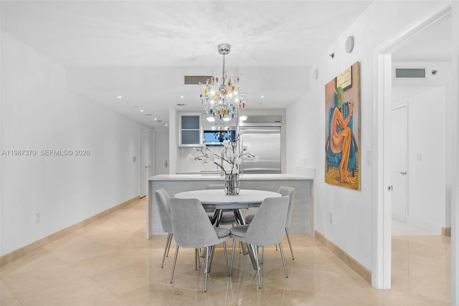 A dining area with a round table and chairs sits before an open kitchen — 1850 S Ocean Dr # 4206, Hallandale Beach FL 33009, HALLANDALE BEACH, FL
