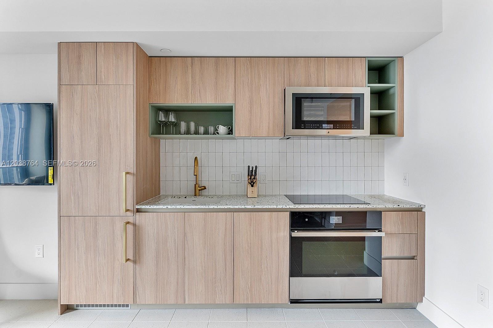 A modern kitchen features light wood cabinetry, a stainless steel oven, and a white backsplash — 159 NE 6th St # 2903, Miami FL 33132, MIAMI, FL