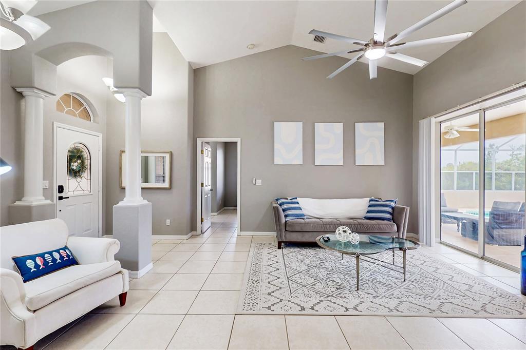 A living room features tile floors, a vaulted ceiling with a fan, and a sofa — 1736 NATRONA DRIVE, NORTH PORT, FL