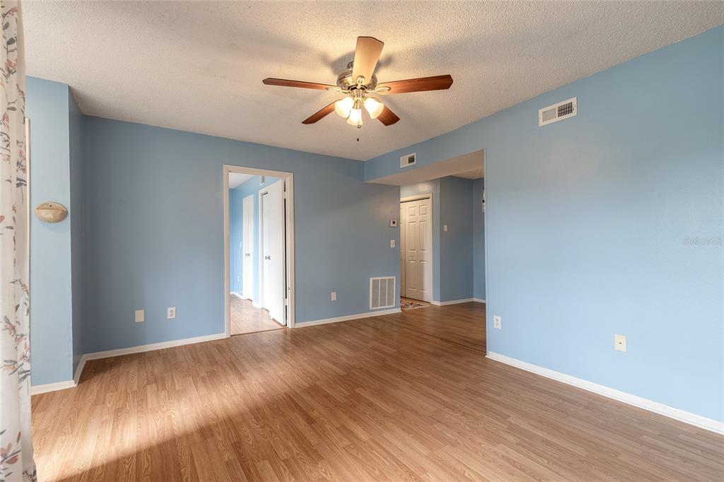 A room with light blue walls, wood-look flooring, and a ceiling fan — 1600 BIG TREE ROAD UNIT B7, SOUTH DAYTONA, FL