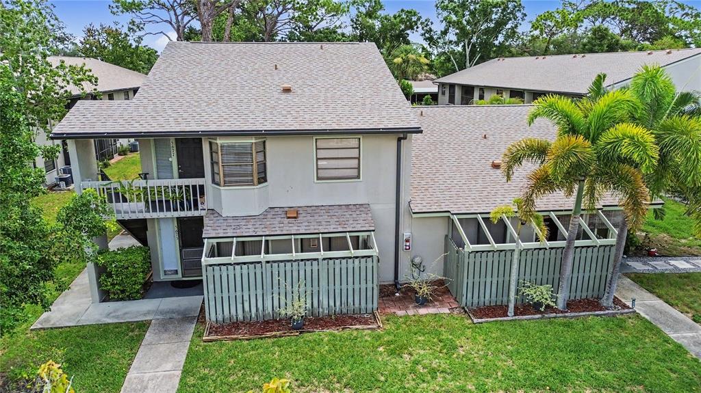 An exterior view of a two-story townhouse with a fenced patio and a palm tree — 5677 SUMMER SIDE LANE UNIT 31B, SARASOTA, FL