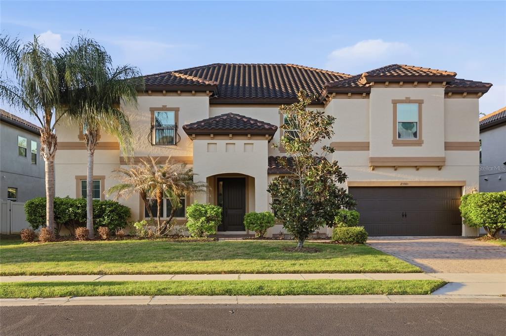 A two-story stucco house with a tile roof, a two-car garage, and front landscaping — 2330 KELBROOK COURT, OVIEDO, FL