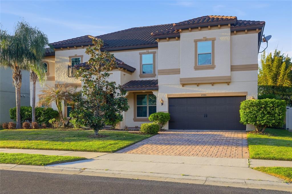 A two-story stucco house with a tile roof, a two-car garage, and a paved driveway — 2330 KELBROOK COURT, OVIEDO, FL