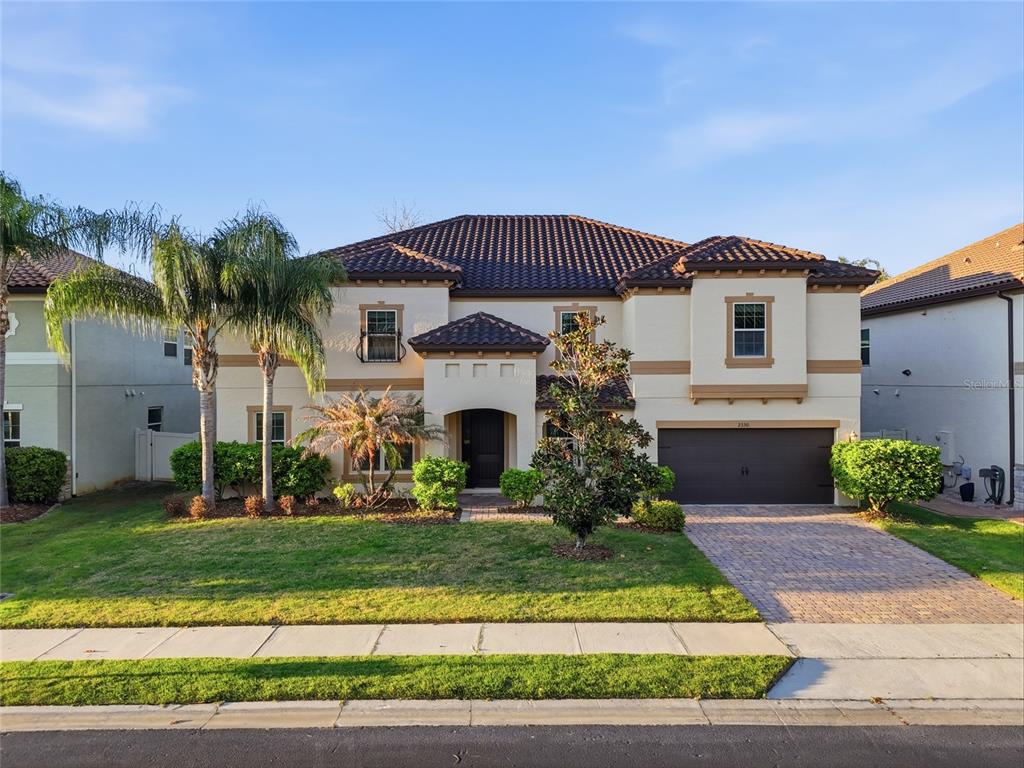 A two-story stucco house with a tile roof, a two-car garage, and a paved driveway — 2330 KELBROOK COURT, OVIEDO, FL