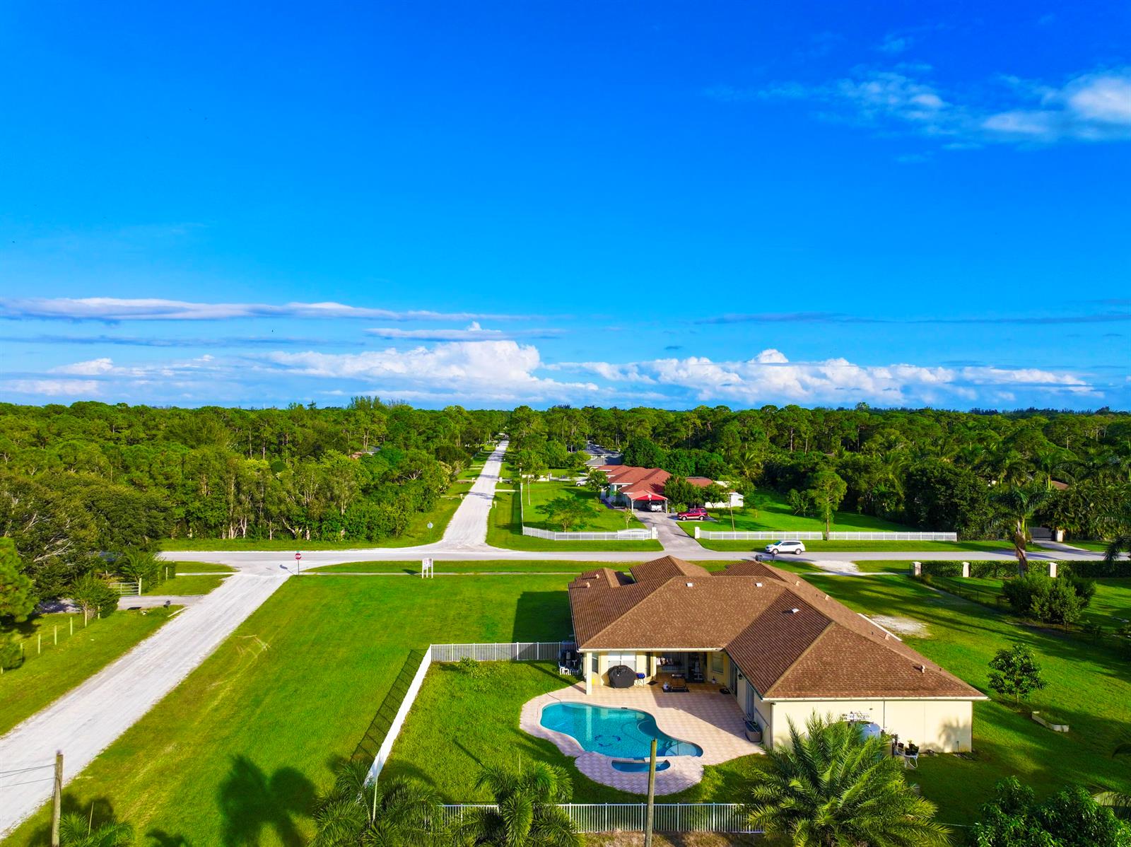 An aerial view shows a house with a brown roof and a backyard swimming pool — 6613 Hall Boulevard, FL 33470, FL