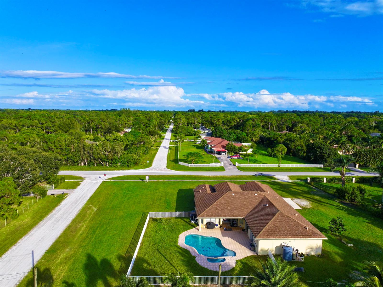 An aerial view of a suburban house with a swimming pool and a large lawn — 6613 Hall Boulevard, FL 33470, FL