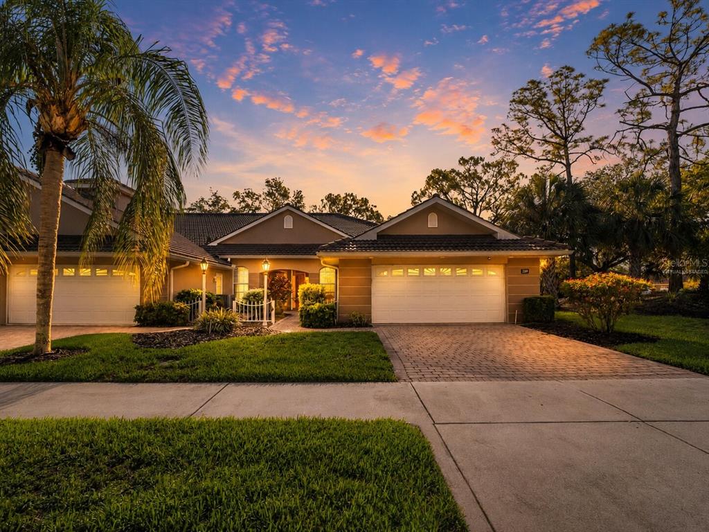 A paved walkway leads to the front entrance of a house with two lamp posts — 2189 LYNX RUN UNIT 2189, NORTH PORT, FL