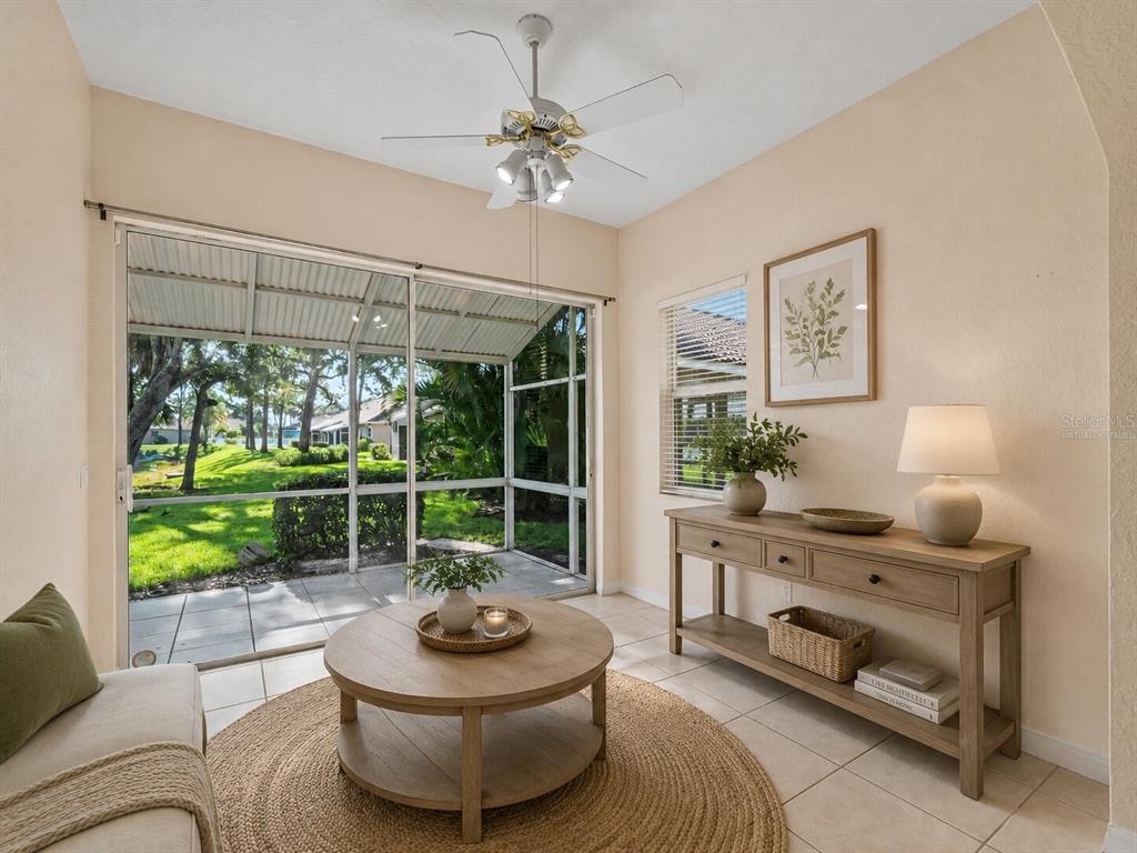 A sunroom features a round wooden coffee table, a console table, and a sliding glass door — 2189 LYNX RUN UNIT 2189, NORTH PORT, FL