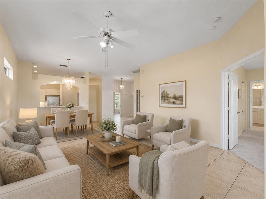 A living room with beige walls, tile floors, a ceiling fan, and neutral-toned furniture — 2189 LYNX RUN UNIT 2189, NORTH PORT, FL
