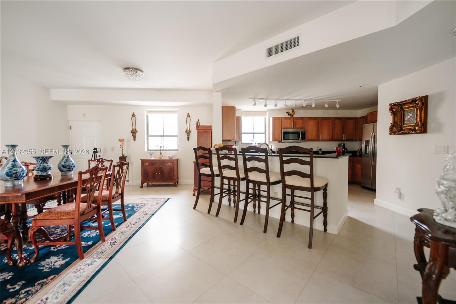 A dining room features a wooden table, chairs, a sideboard, and a blue area rug — 8390 SW 72nd Ave # 707, Miami FL 33143, MIAMI, FL