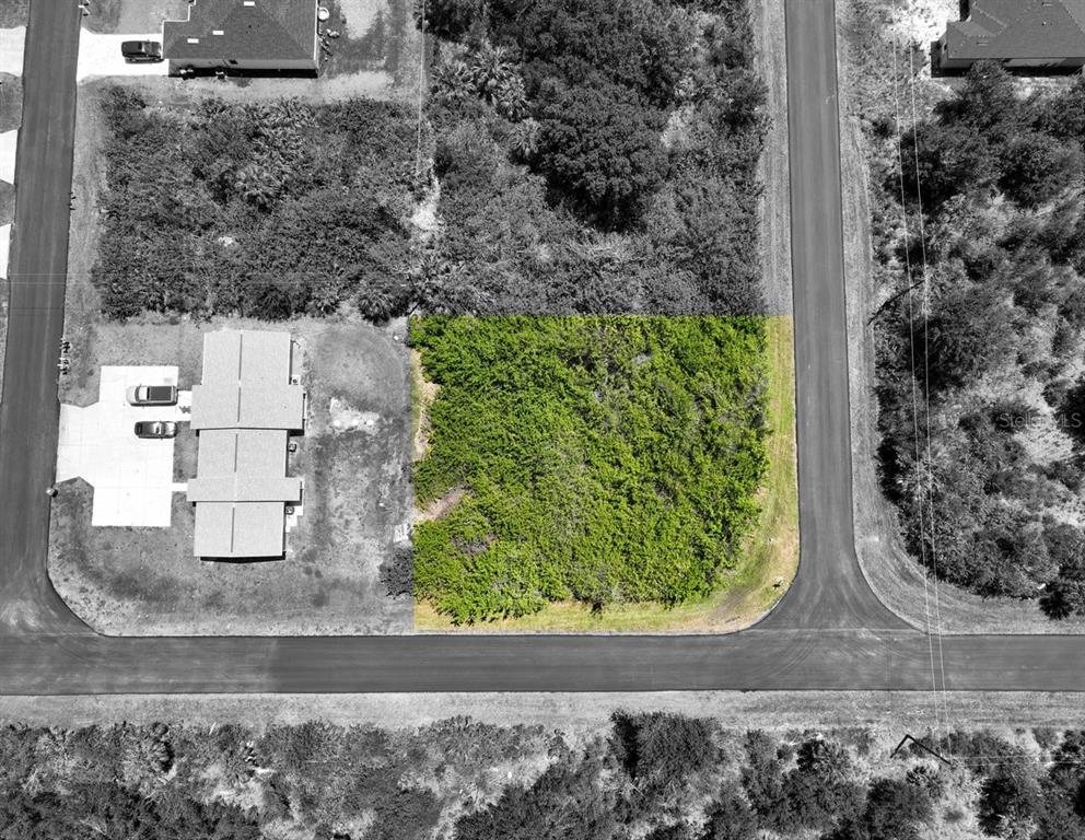 An aerial view shows a vacant, rectangular lot highlighted in green next to a residential house — 12204 KIRK AVENUE, PORT CHARLOTTE, FL