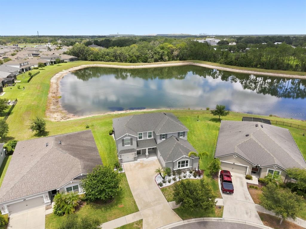 An aerial view shows a two-story house with a pond in the backyard — 10708 PLANER PICKET DRIVE, RIVERVIEW, FL