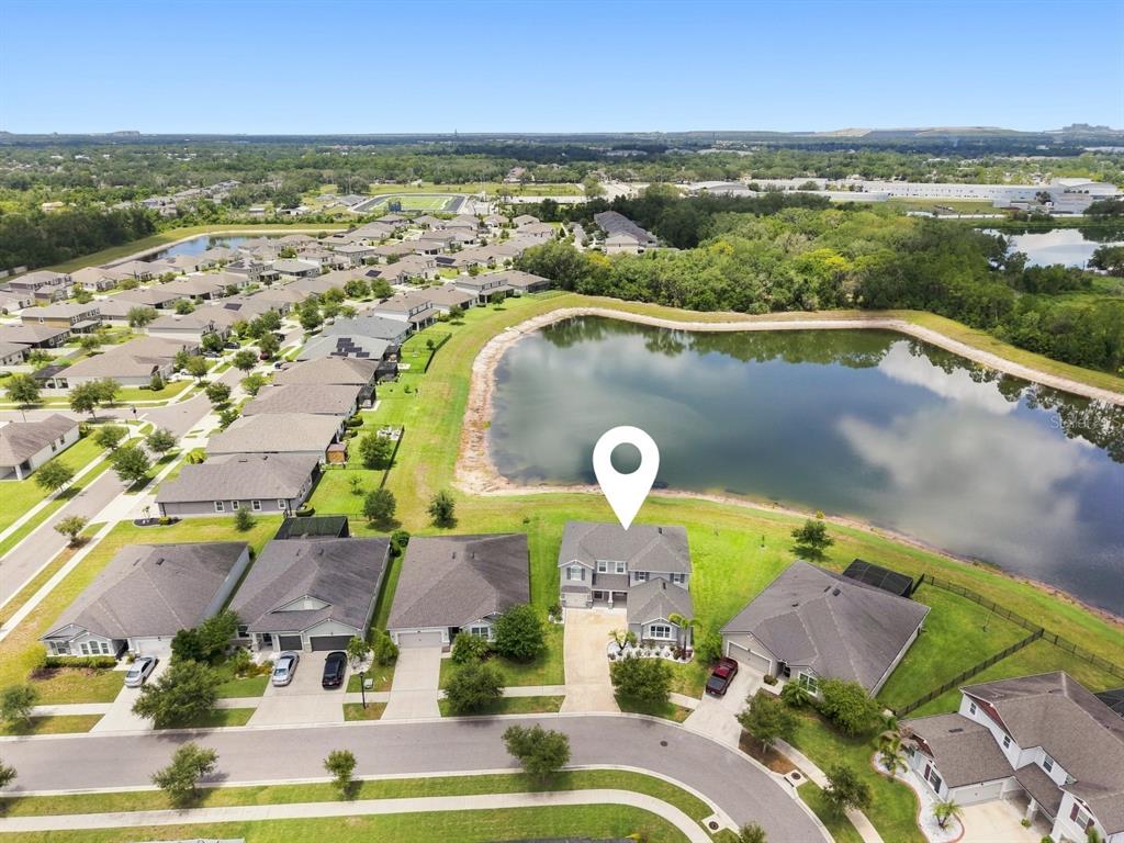 An aerial view shows a suburban house with a white location pin by a pond — 10708 PLANER PICKET DRIVE, RIVERVIEW, FL