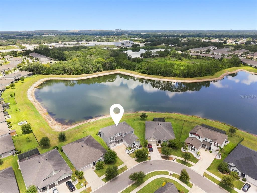 An aerial view shows a suburban house with a white location pin overlooking a lake — 10708 PLANER PICKET DRIVE, RIVERVIEW, FL