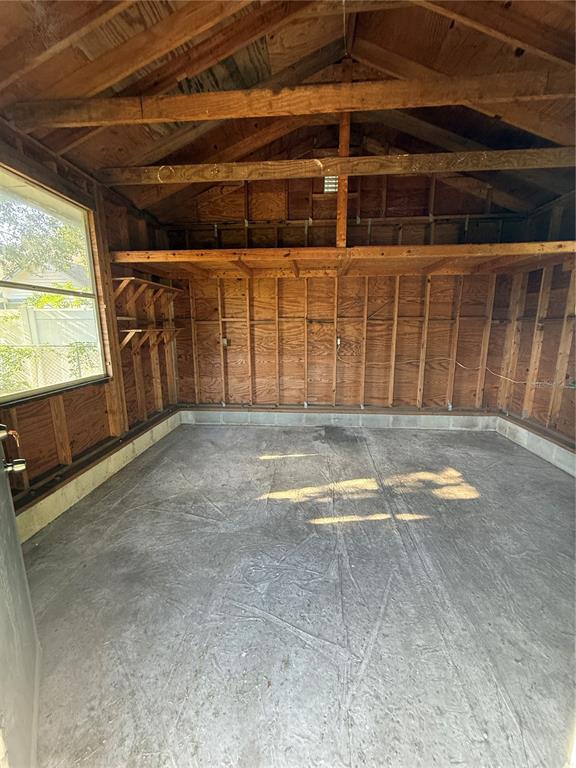 An interior view of a wooden shed with a concrete floor and exposed wall studs — 3802 E ESTHER STREET, ORLANDO, FL
