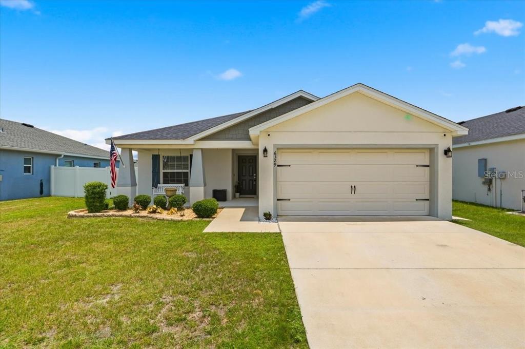 A single-story suburban house with a two-car garage and a front porch — 6329 GARDNER DRIVE, LAKELAND, FL