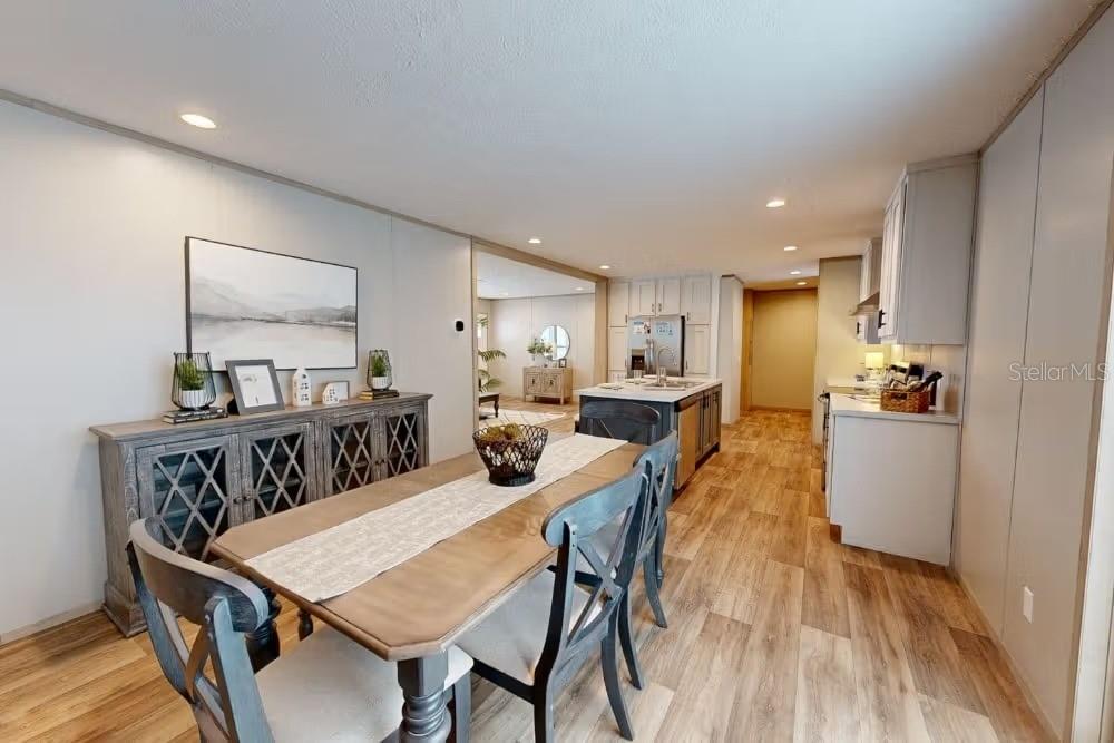 A dining area with a wooden table and chairs sits adjacent to a modern kitchen — 19359 NW 274TH STREET, OKEECHOBEE, FL