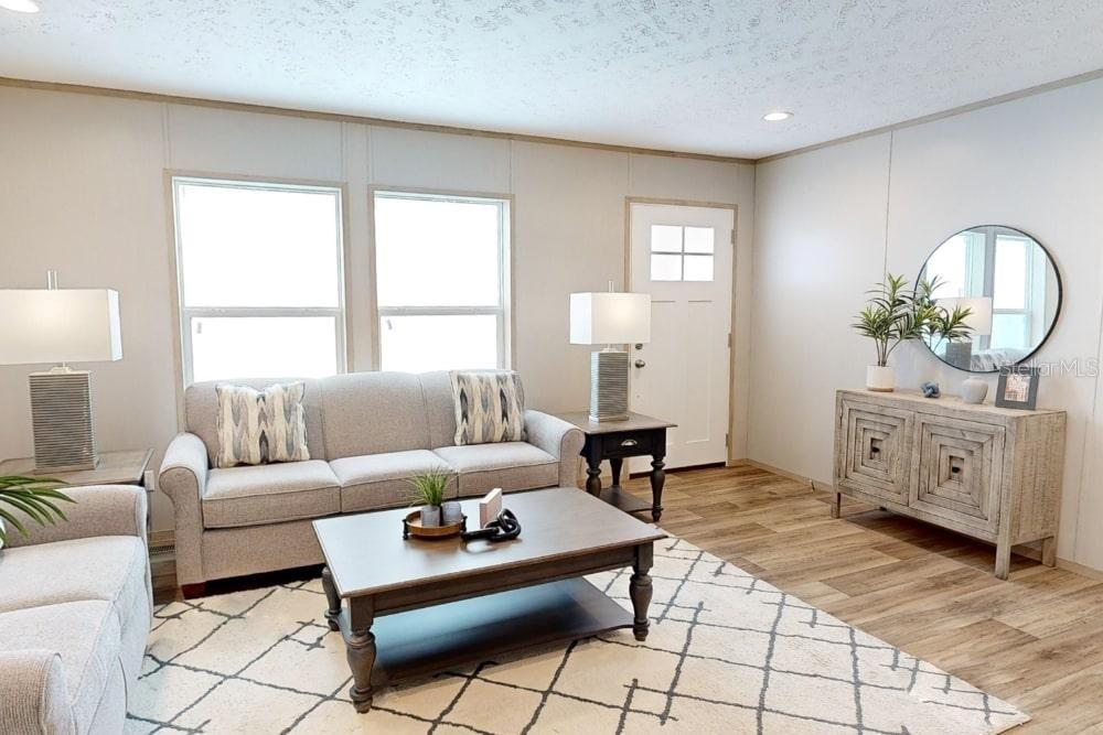A living room features a gray sofa, a coffee table, and a wooden console table — 19359 NW 274TH STREET, OKEECHOBEE, FL