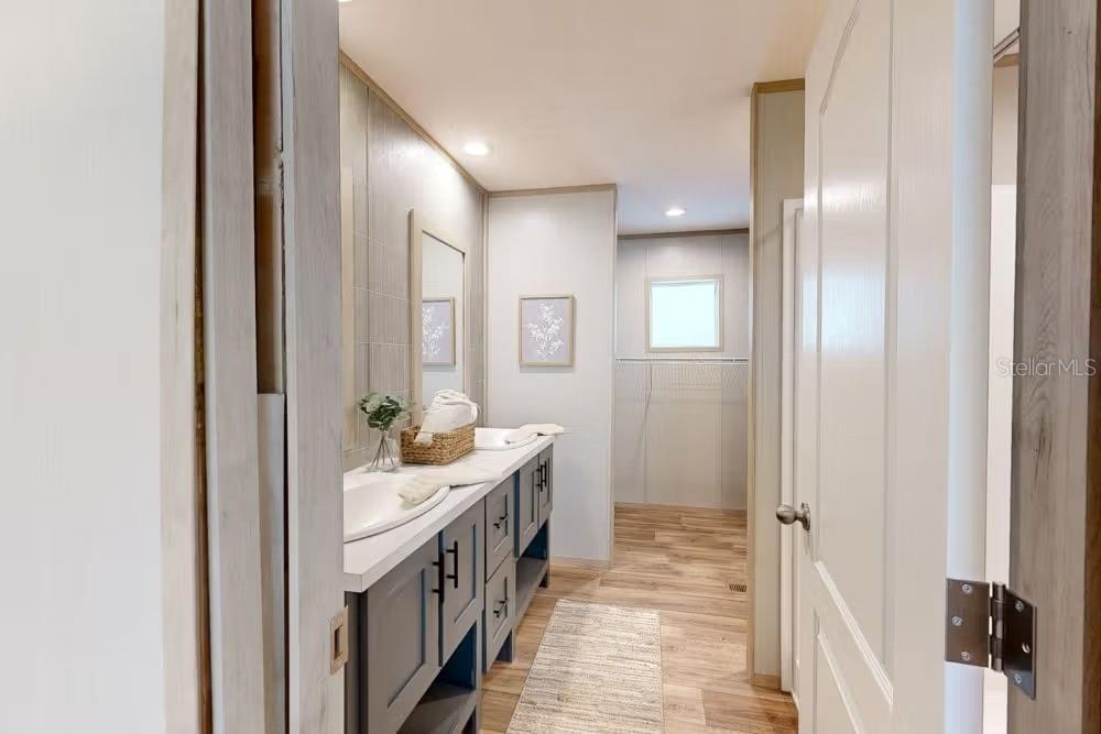 A bathroom features a double vanity with grey cabinets, light countertops, and wood-look flooring — 19359 NW 274TH STREET, OKEECHOBEE, FL