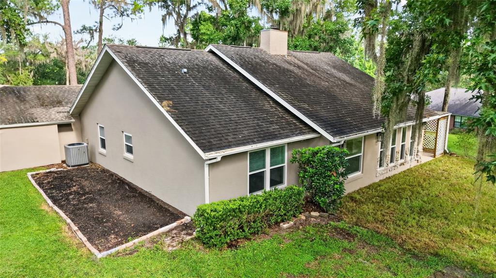 An exterior view of a house with a dark shingled roof and beige stucco siding — 4849 NW 83RD COURT, OCALA, FL