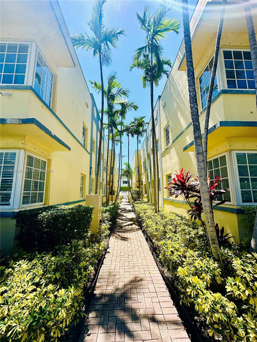 A brick walkway leads between two yellow, two-story apartment buildings lined with palm trees — 600 Euclid Ave # 4B, Miami Beach FL 33139, MIAMI BEACH, FL