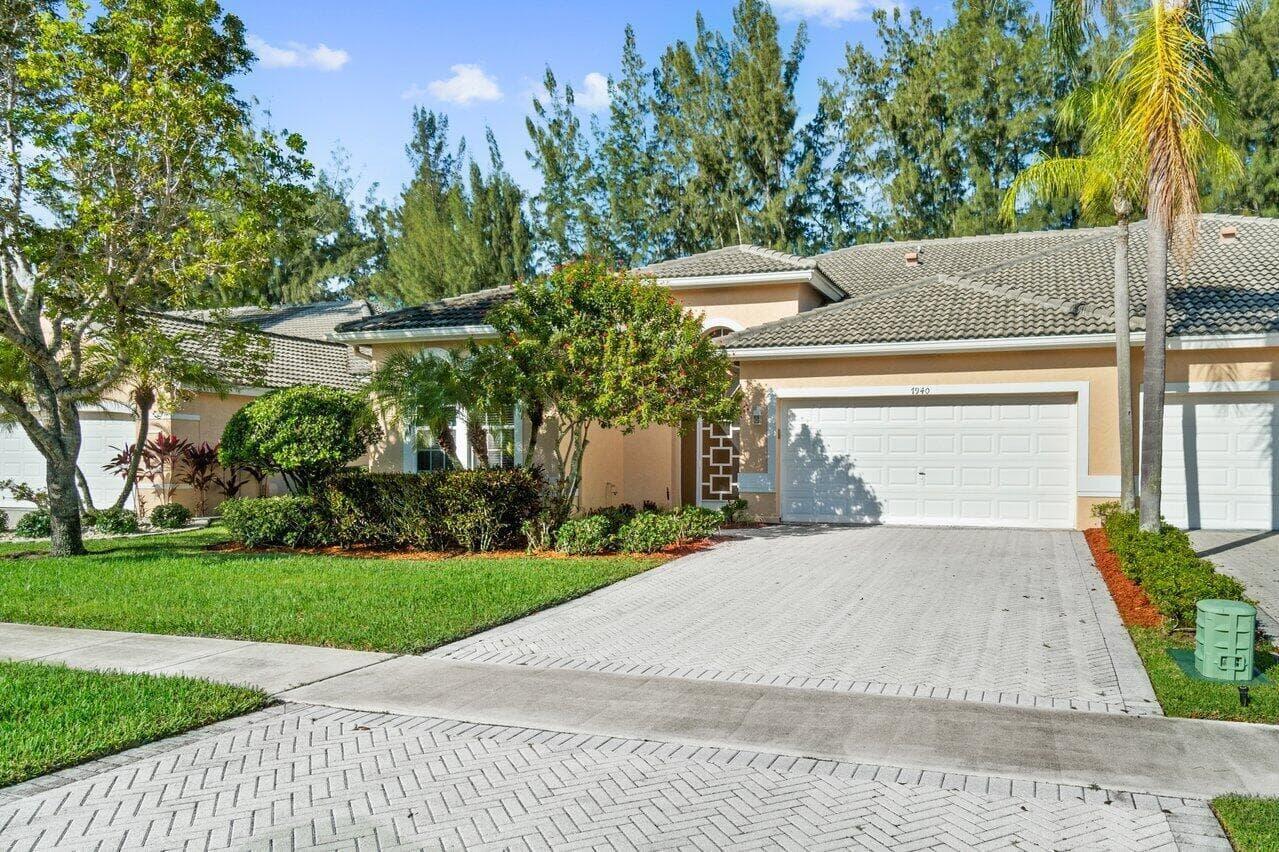 A single-story suburban house with a beige exterior, tiled roof, and a paved driveway — 7940 Rockford Road, Boynton Beach FL 33472, BOYNTON BEACH, FL