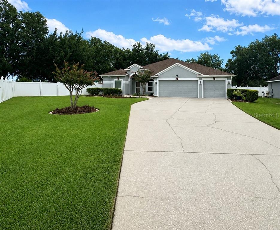 An aerial view of a single-story house with a gray exterior, brown roof, and driveway — 2025 WINTERMERE POINTE DRIVE, WINTER GARDEN, FL