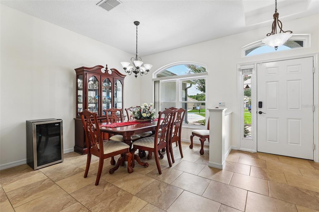 A dining room features a wooden table with chairs, a china cabinet, and tile flooring — 2025 WINTERMERE POINTE DRIVE, WINTER GARDEN, FL