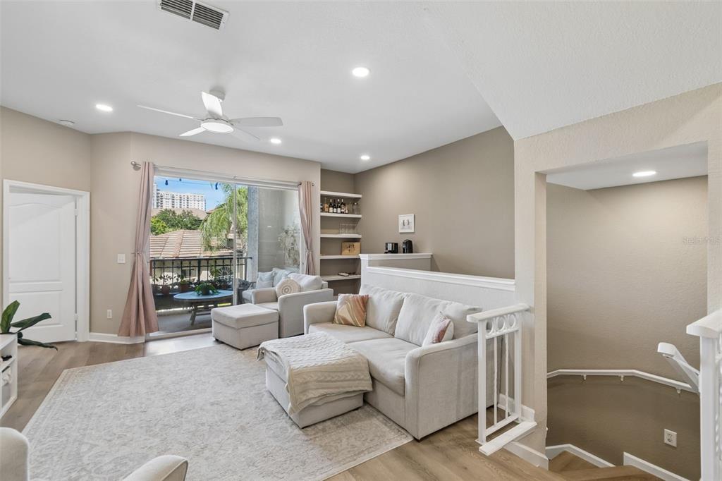 A living room features a sectional sofa, built-in shelving, and a sliding door to a balcony — 708 SEABOARD PLACE UNIT 708, TAMPA, FL