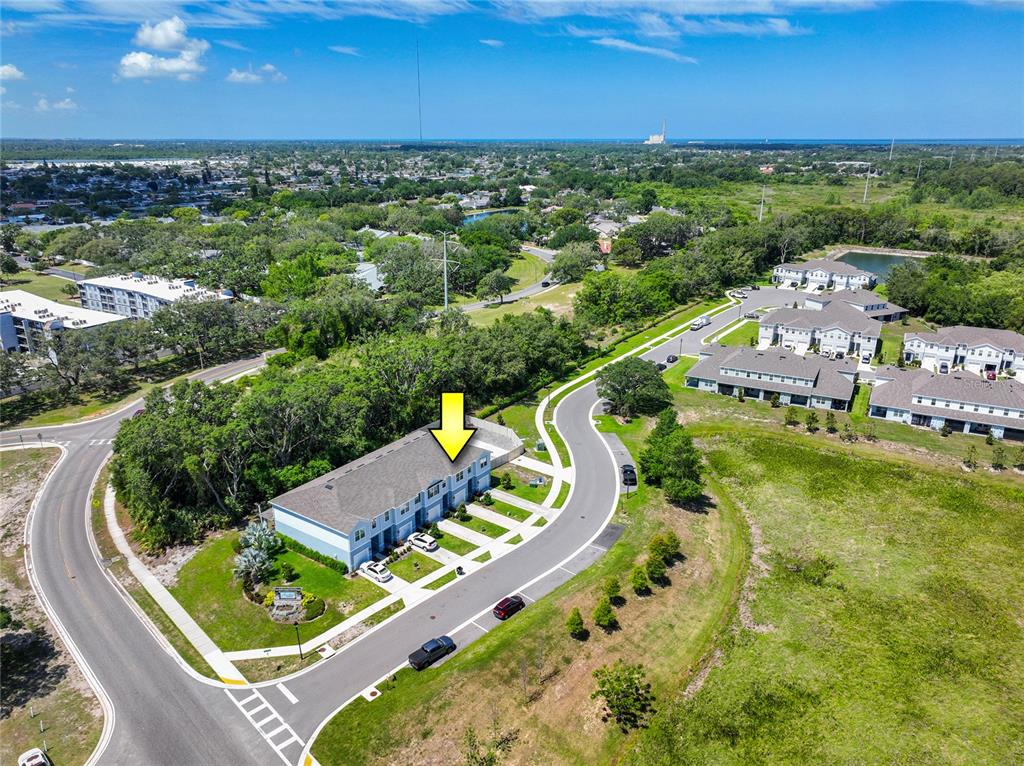 An aerial view shows a multi-unit townhouse building with a yellow arrow pointing downward — 4298 HARBOUR PALM DRIVE, HOLIDAY, FL