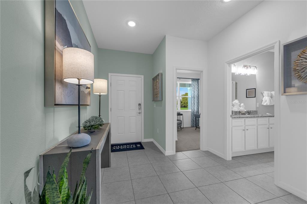 A tiled entryway features a console table, two lamps, and doorways leading to other rooms — 33936 SEATTLE SLEW DRIVE, SORRENTO, FL