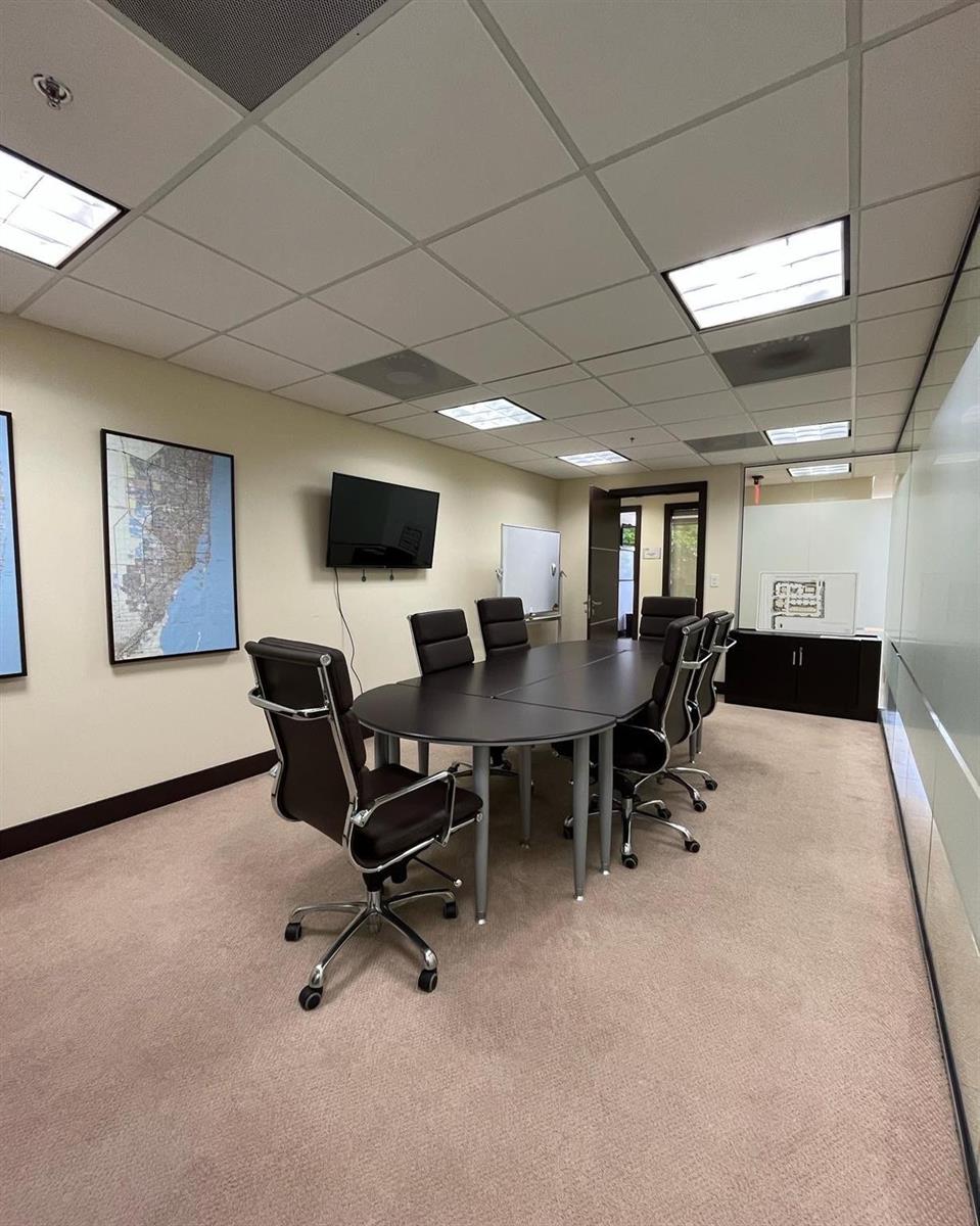 A conference room features a dark oval table, rolling chairs, a wall-mounted television, and maps — 2730 SW 3rd Avenue # 202m, Miami FL 33129, MIAMI, FL