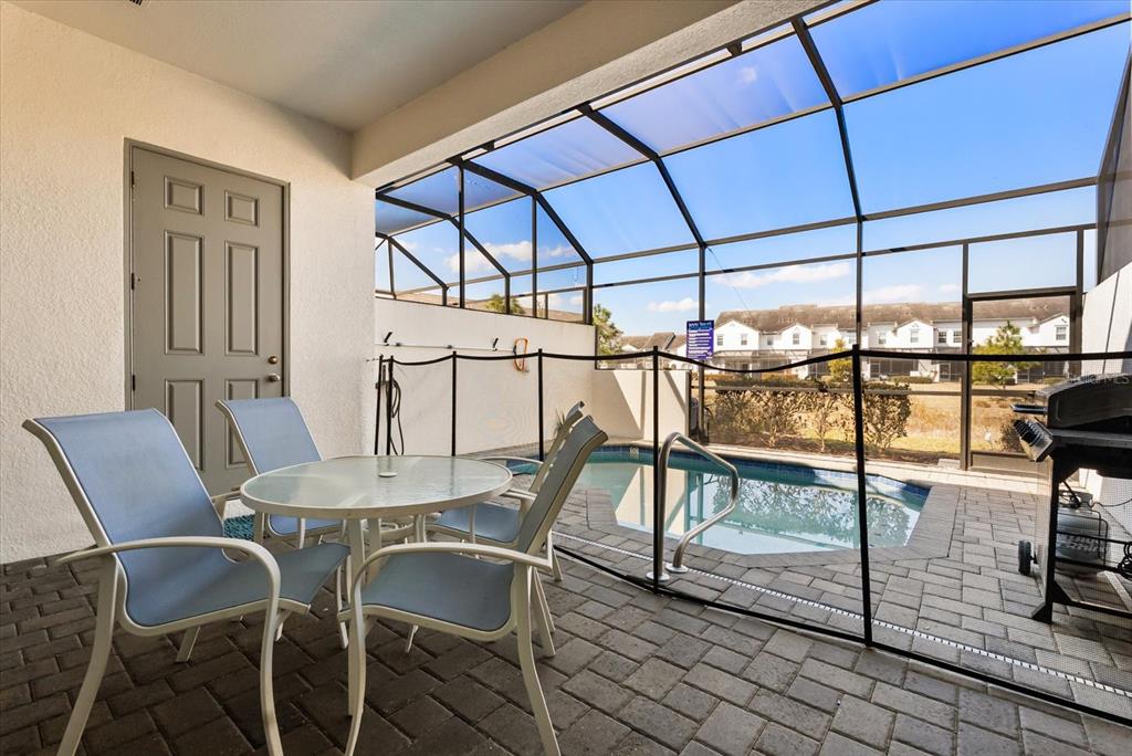 A patio features a small pool, a dining set, and a black safety fence enclosure — 337 CAPTIVA DRIVE, DAVENPORT, FL