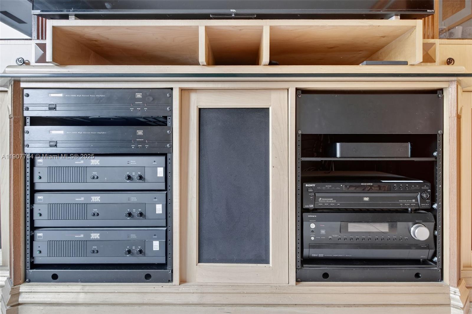 A wooden media cabinet contains several stacked audio components and a television on top — 15010 Dunbarton Pl, Miami Lakes FL 33016, MIAMI LAKES, FL
