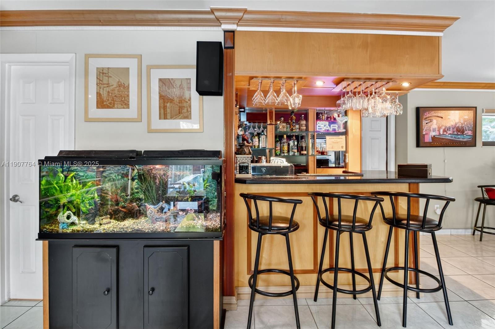A home bar area features a fish tank, three stools, and hanging glassware — 15010 Dunbarton Pl, Miami Lakes FL 33016, MIAMI LAKES, FL