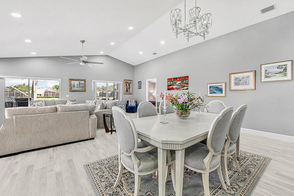 A dining area with a light-colored table and chairs sits adjacent to a living room — 8075 Duomo Circle, Boynton Beach FL 33472, BOYNTON BEACH, FL