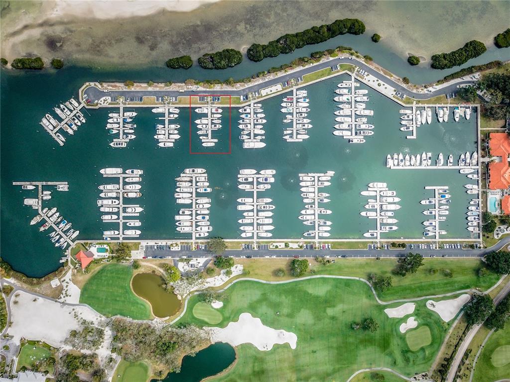 Aerial view of a marina with numerous boats docked in slips alongside a golf course — 2600 HARBOURSIDE DRIVE UNIT O-04, LONGBOAT KEY, FL