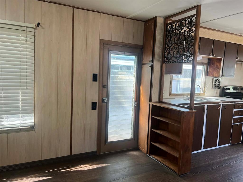 A kitchen area features wood-paneled walls, a glass-paneled door, and a decorative room divider — 7801 34TH AVENUE N UNIT 88, ST PETERSBURG, FL