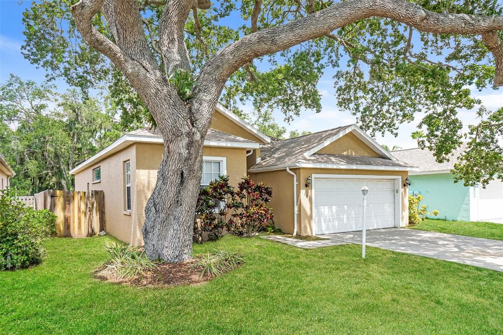 A single-story house with a tan exterior, a two-car garage, and a large oak tree — 1840 SUMMER WALK CIRCLE, SARASOTA, FL